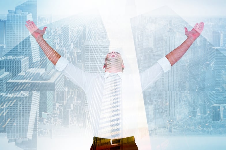 Handsome businessman cheering with arms up against low angle view of skyscrapers.jpeg